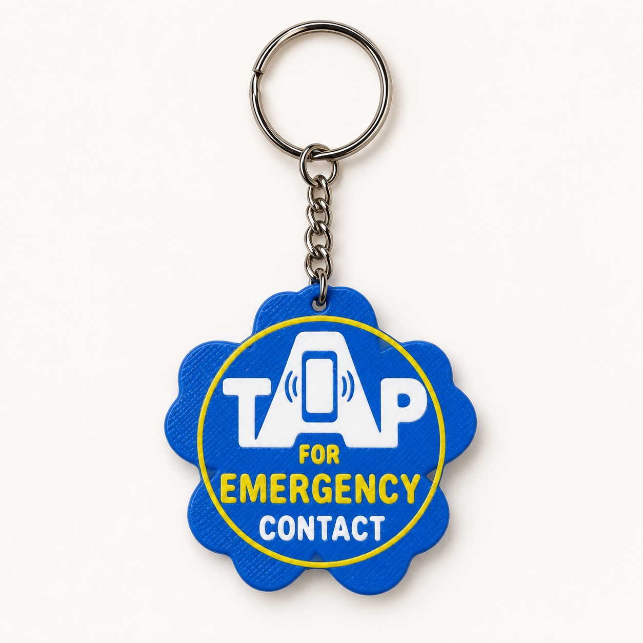 Blue forget-me-not flower KinTag with yellow and white tap-for-emergency-contact lettering, attached to a keyring